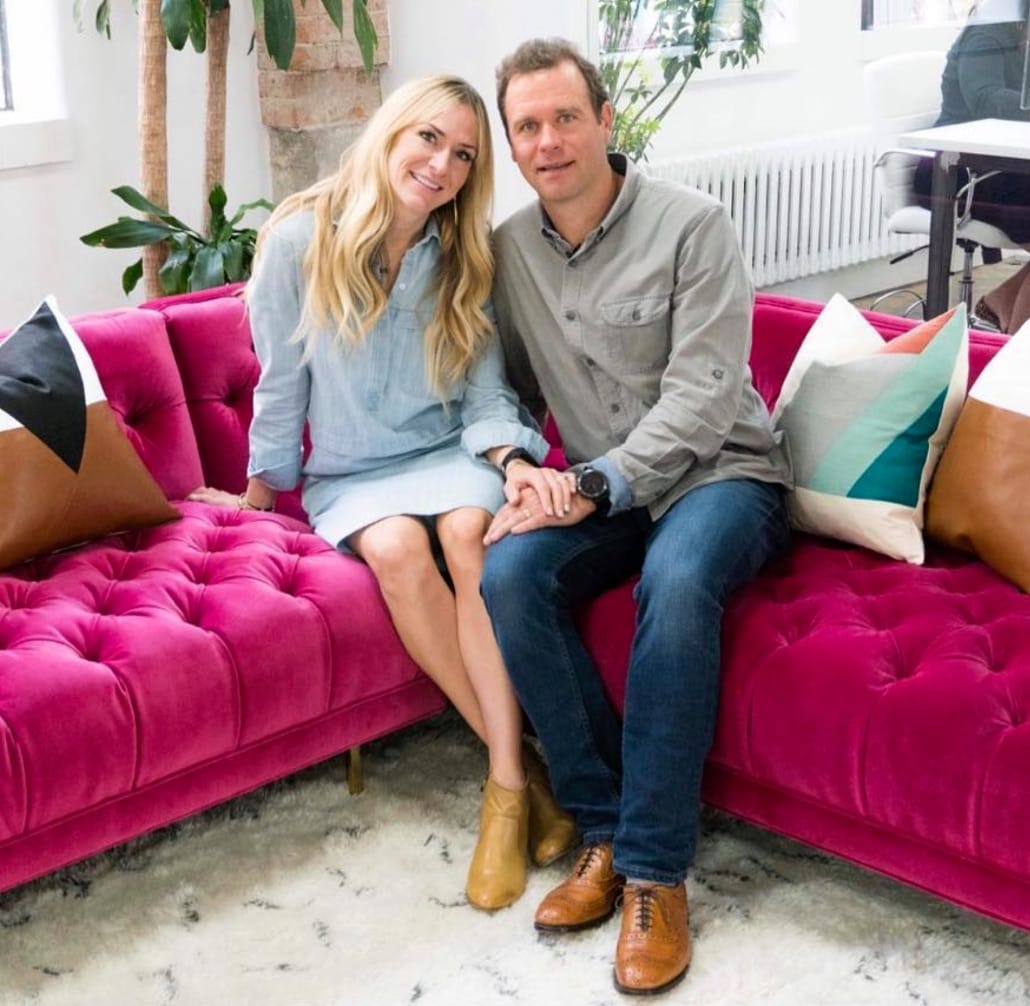 Sam Alexander, CEO, and spouse sitting on a pink couch.